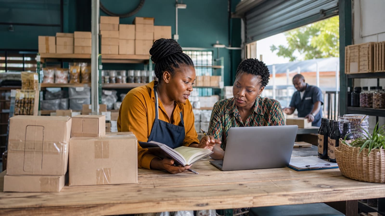 Small-business owner reviewing cash flow alongside stock and customer orders